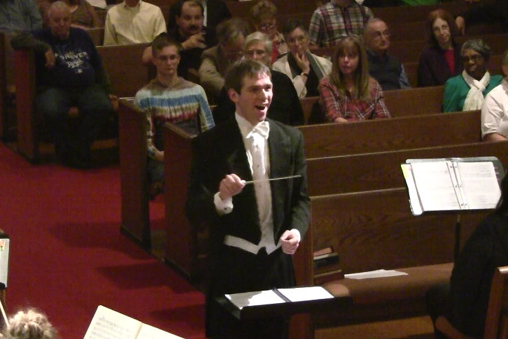 Photograph of Bram directing choral and orchestral performers at the University of Missouri - Kansas City.